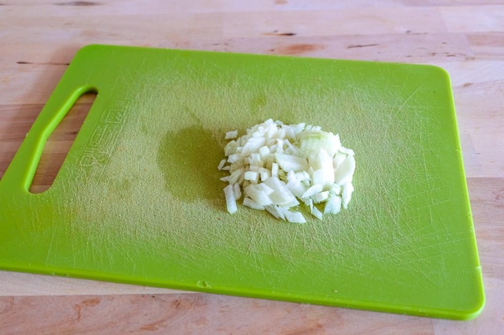 chopped onions on green cutting board zucchini fritters recipe