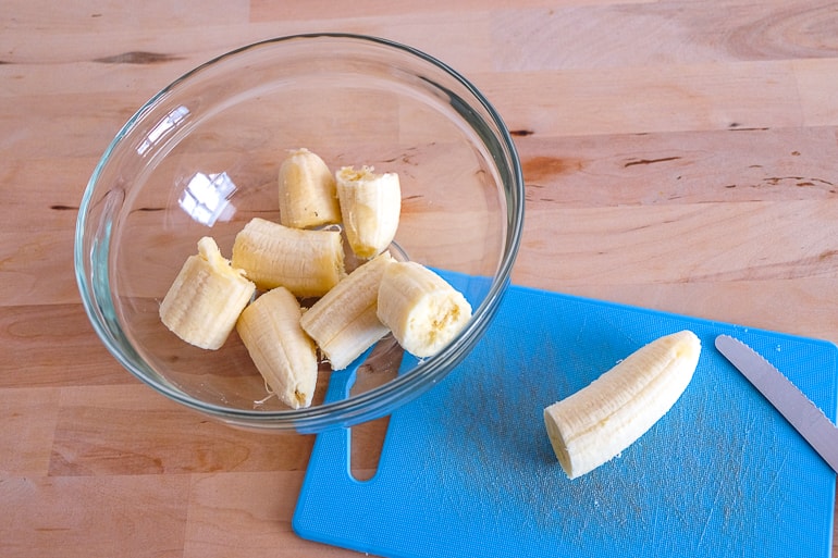 cut bananas in clear bowl on table vegan buckwheat banana pancakes