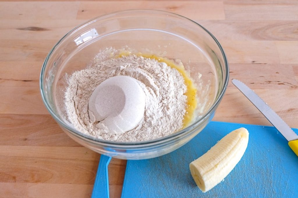 flour in bowl on wooden table with banana vegan buckwheat banana pancakes