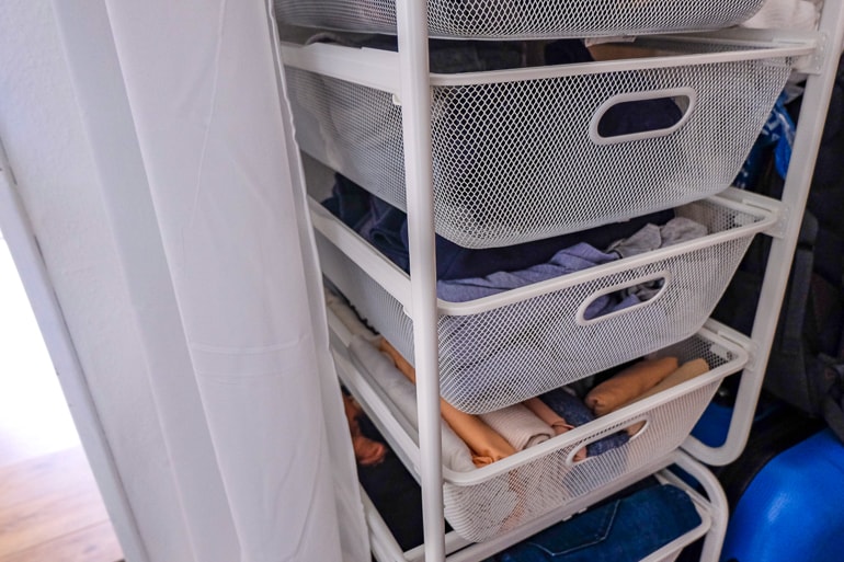white metal clothing shelves with folded clothes how to store your clothes without a closet or dresser