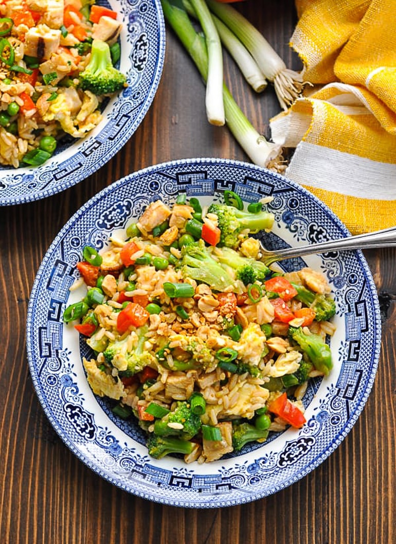 fried rice in blue bowl on table with spoon 