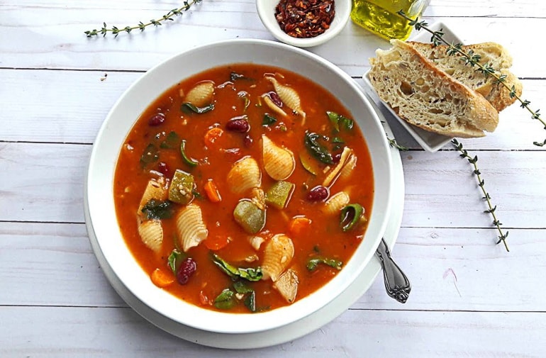 red soup with noodles in white bowl healthy minestrone soup