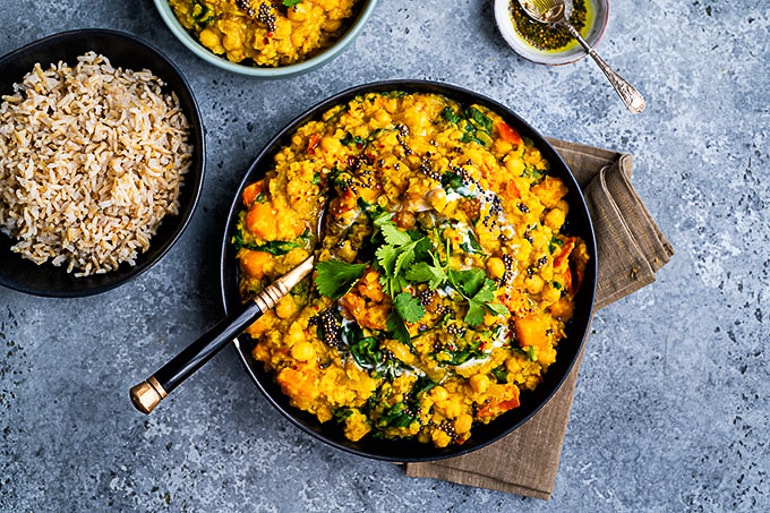lentil and chickpea dhal in black dish in blue table