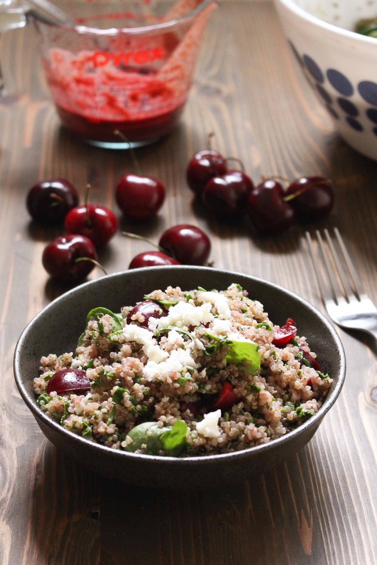 bowl with quinoa salad and cherries on table
