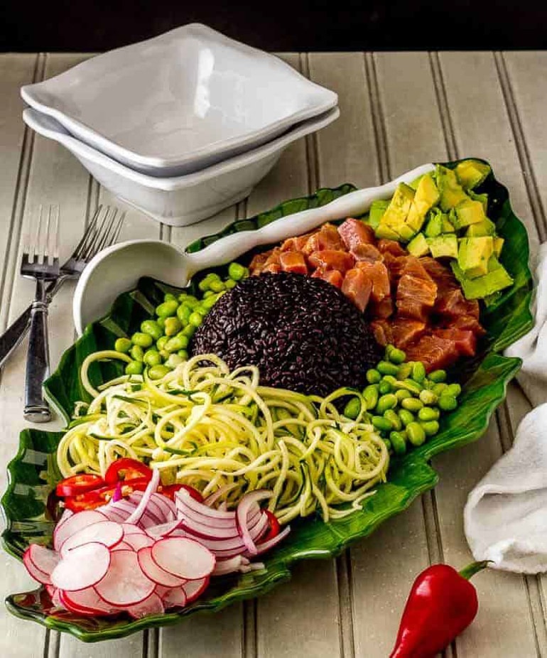 green bowl filled with tuna poke noodles and vegetables 