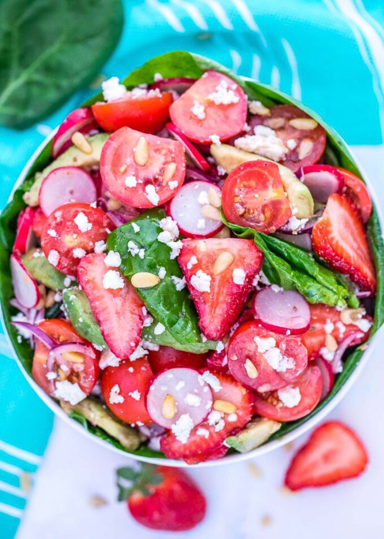 strawberry salad with spinach in bowl in table