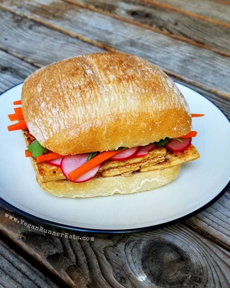 Banh mi Sandwich with radishes and carrots on white plate 