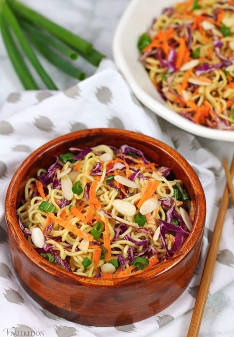 Ramen salad with shredded carrot and other vegetables in wooden bowl