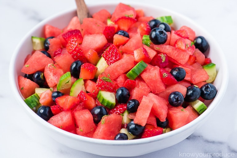 cut up watermelon, cucumber, blueberries and mint in white bowl