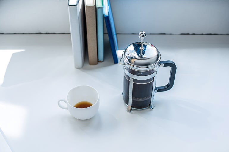silver french press with coffee mug on white counter coffee brewing methods