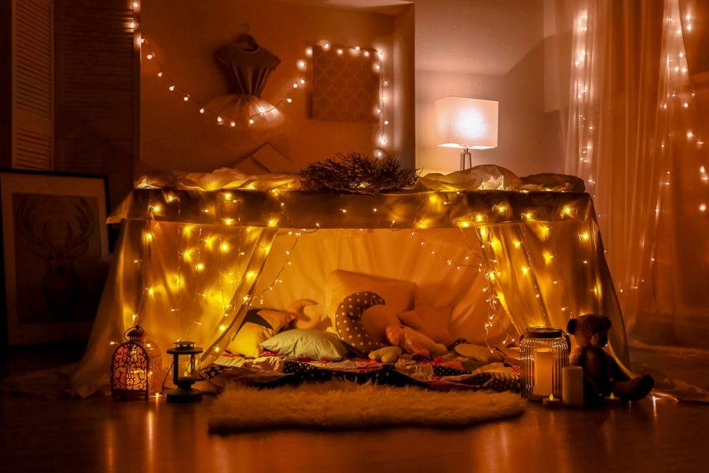 blanket fort in living room with fairy lights date night at home ideas
