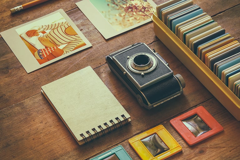 old camera and albums on wooden table date night at home ideas
