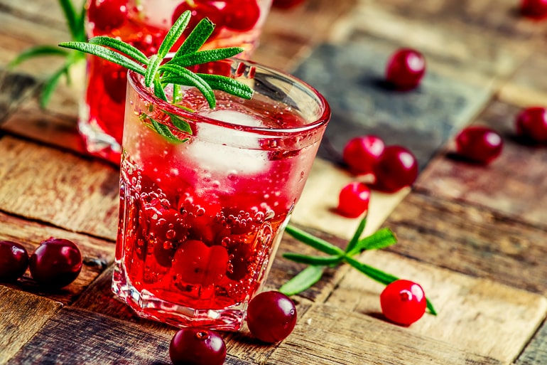 red vodka cranberry in short glass on wooden table top