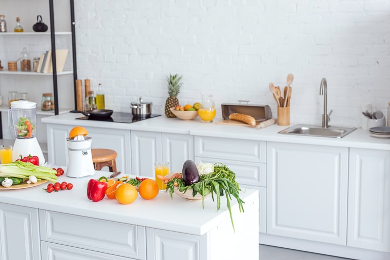 White kitchen with colorful fruit and vegetables on counter healthy eating