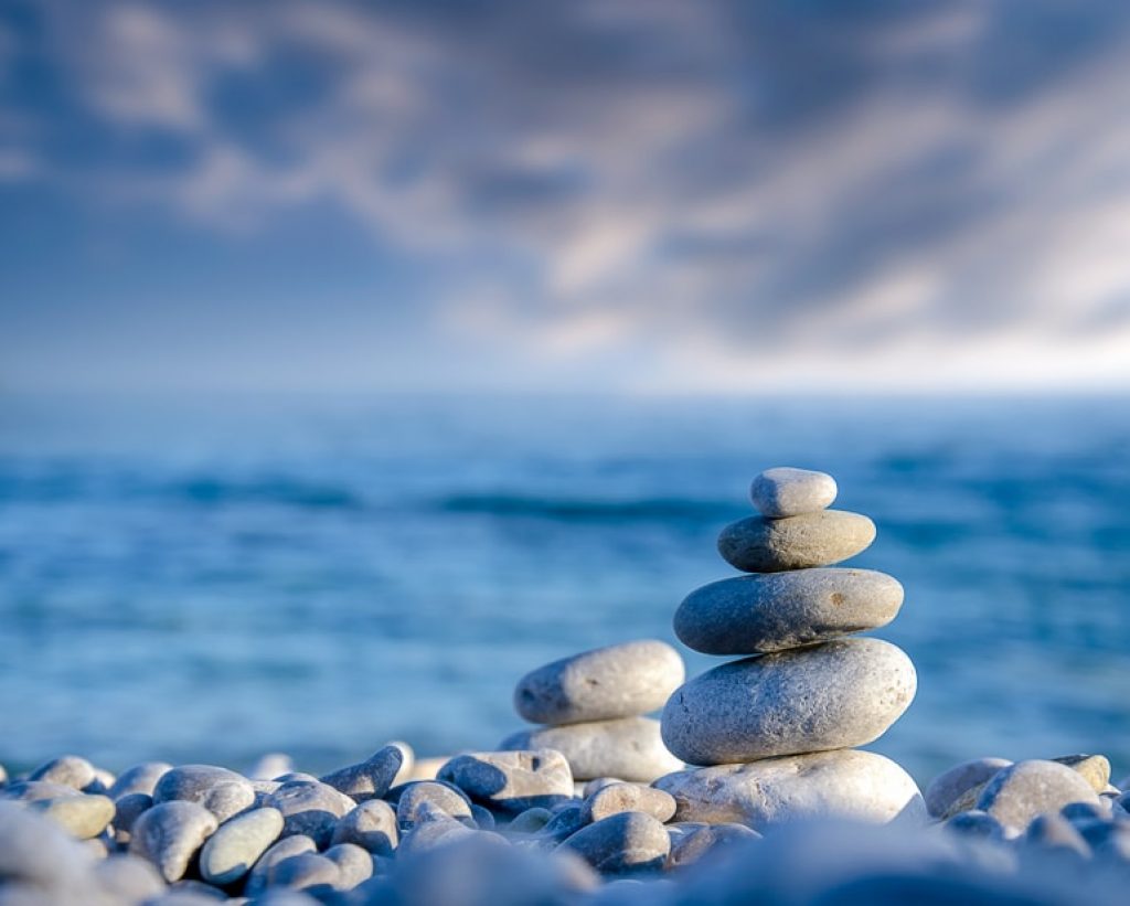 stones balancing on shoreline with sea behind