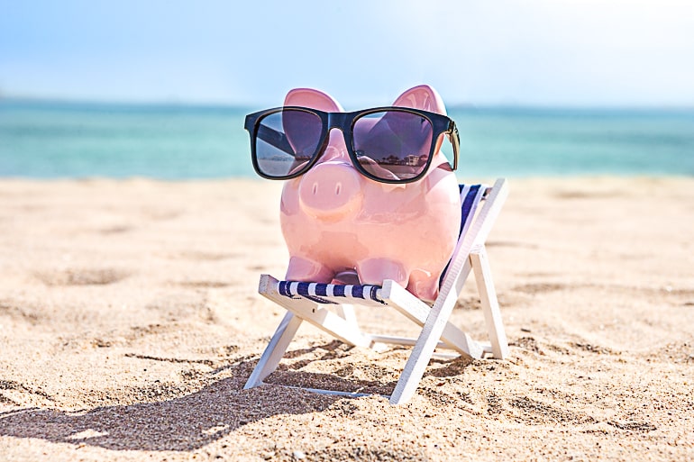 Piggy bank on beach chair with dark sunglasses for saving money article