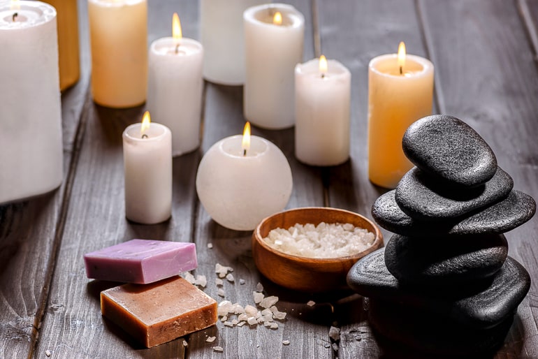 Candles soaps and stones standing on dark wood background stressful day