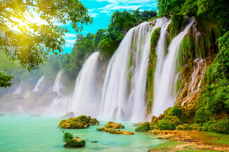 Photo of waterfall and greenery with sun