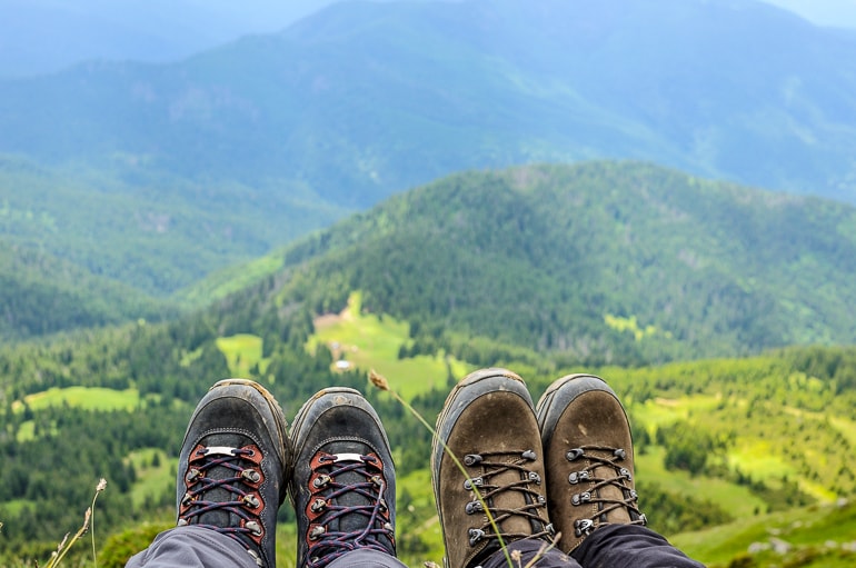 Hiking boots with trees and mountains in background