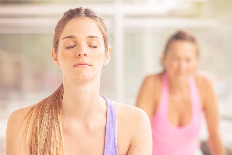 Woman with eyes closed breathing and doing yoga