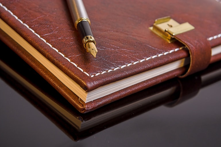 Brown leather bound journal with fountain pen on top