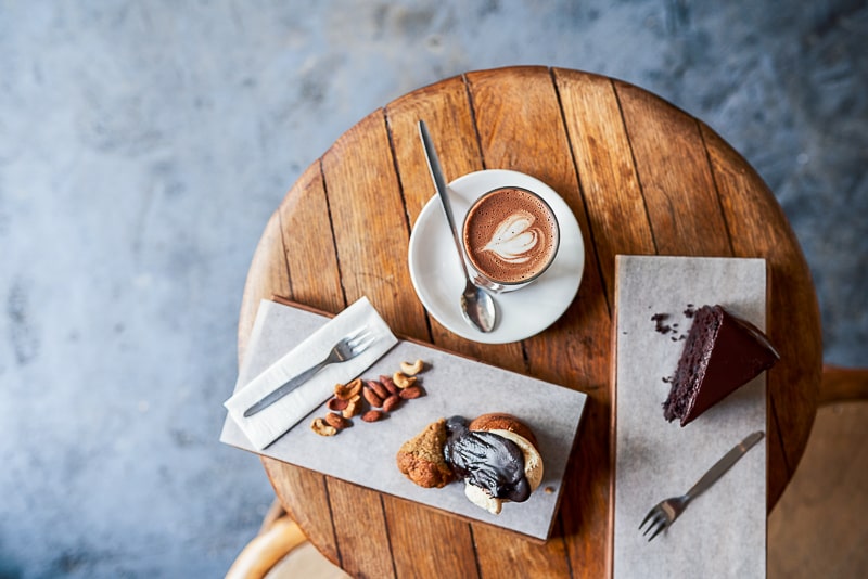 coffee and cake on wooden table shown from above eating habits