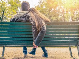 couple sitting in green bench in park dating an introvert