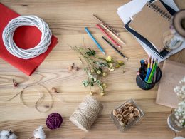 Pencils and twine and other craft supplies on wooden table frugal living tips