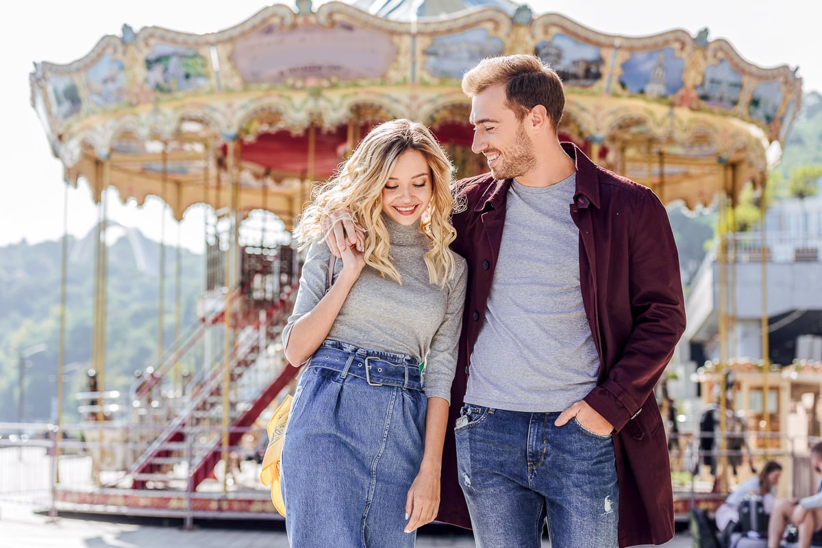 man and woman walking together in front of carousel good first date ideas