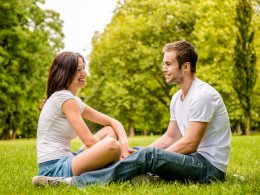 Man and woman sitting in park looking at each other and smiling how to not lose yourself in a relationship