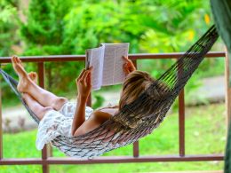 Woman in hammock reading a book with greenery in background self care tips