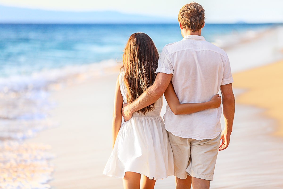 Couple walking on the beach with arms around each other separation anxiety in a relationship