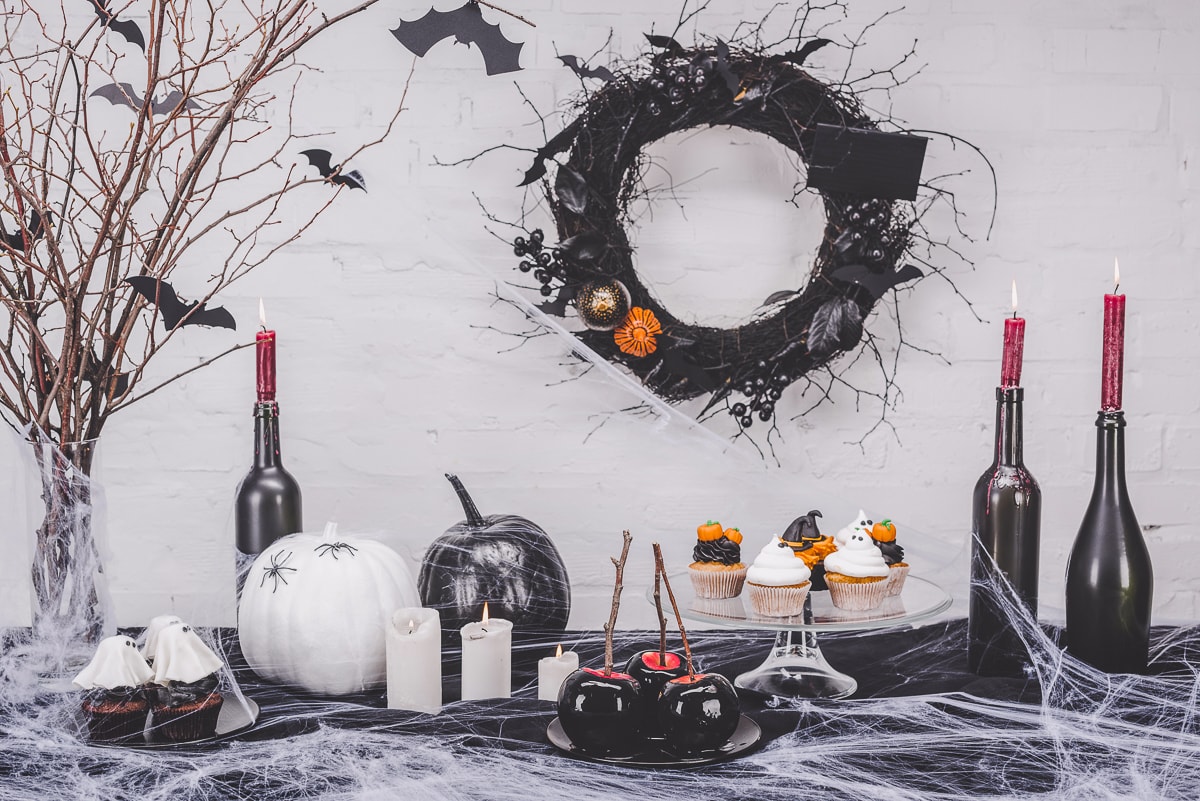 fake spider webs and wine bottles on table cheap halloween decorations