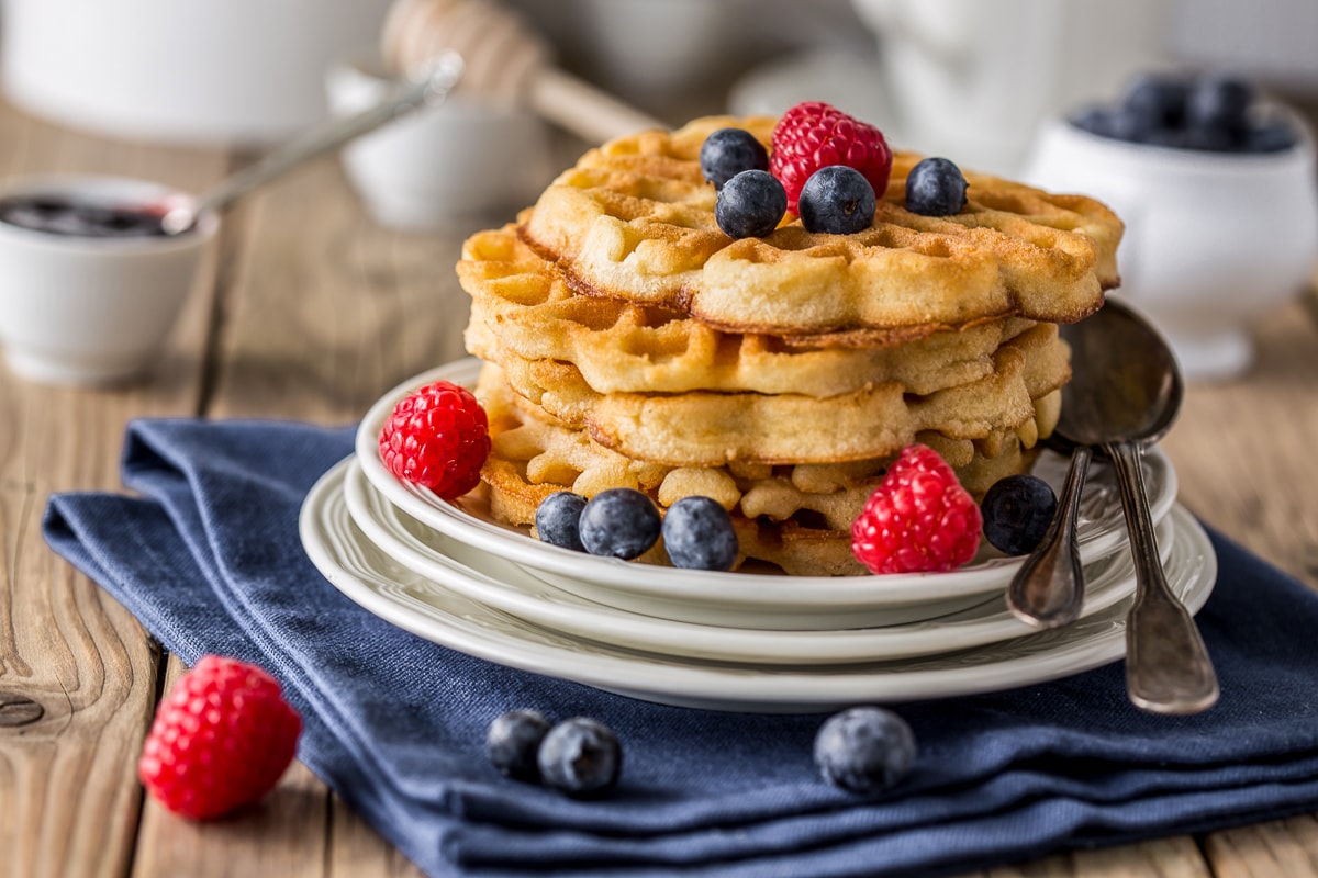 stack of waffles on plate with berries on table waffle recipes