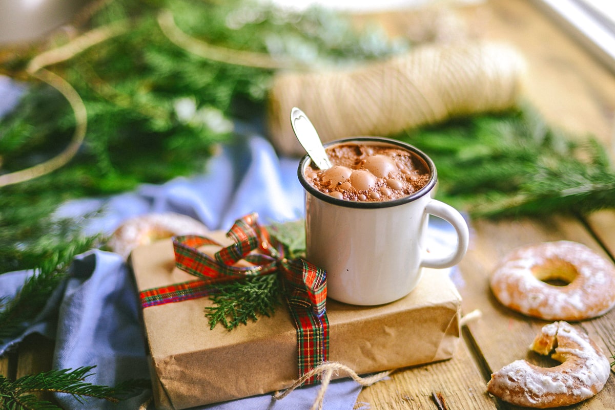 mug of hot chocolate with spoon on secret santa gift box