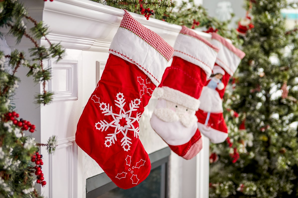 red and white stockings hanging off white fireplace